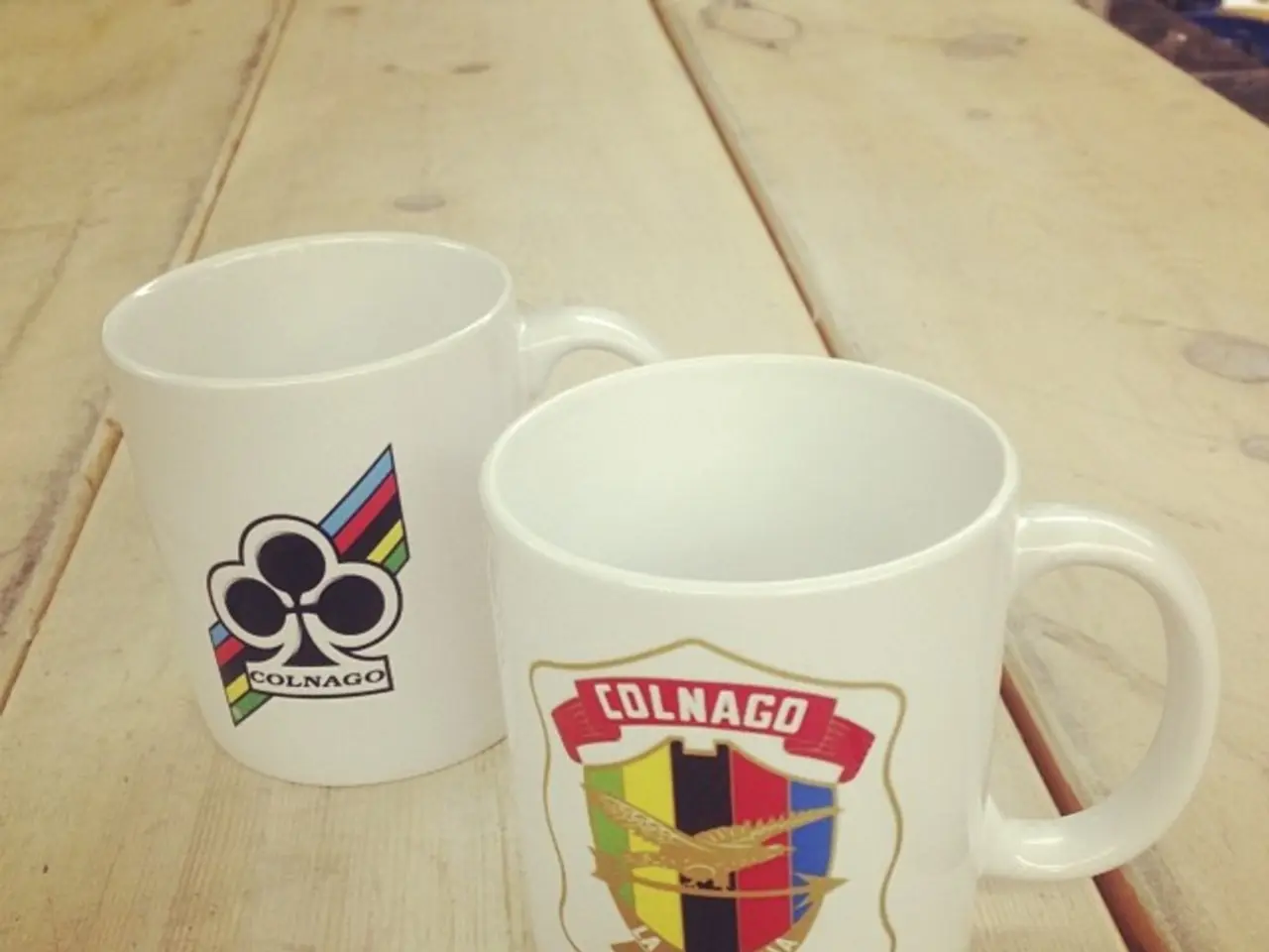 Here we can see two cups on a platform and there is a different logo on each cup.