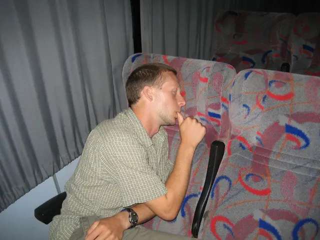 In this image there is a person laying on the chair, and in the background there are chairs and...