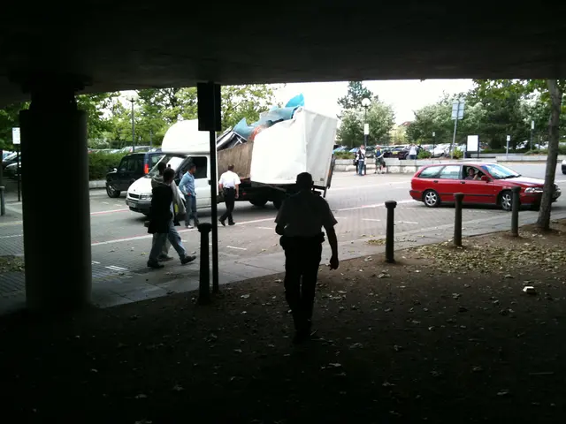 There are so many people walking and there is a car and truck on road.