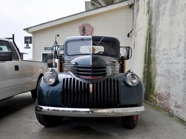 In this picture we can see few vehicles on the path. There are some boards on a house. We can see...