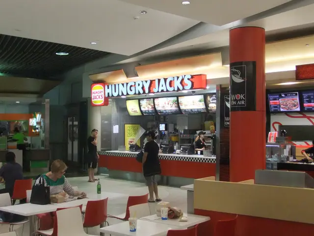 In a restaurant there is food ordering area where woman are standing to take order and on other...